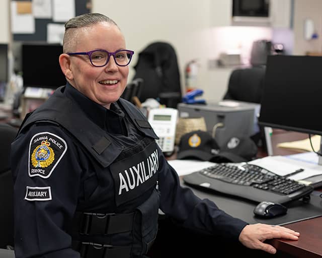Auxiliary officer in uniform at desk
