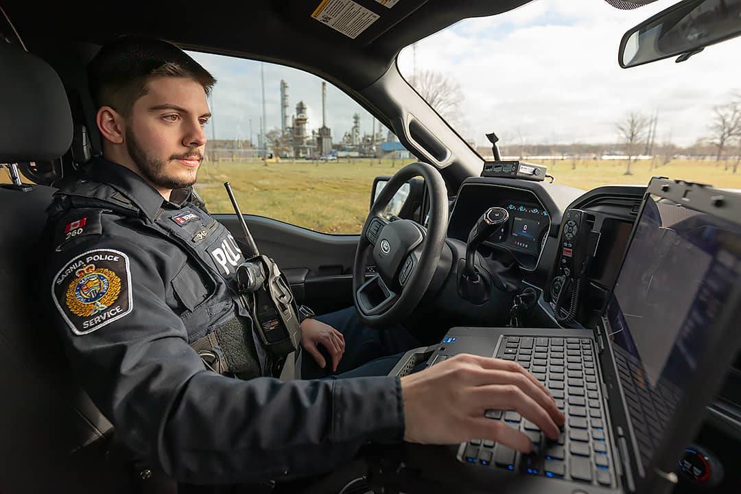 police constable in vehicle on computer